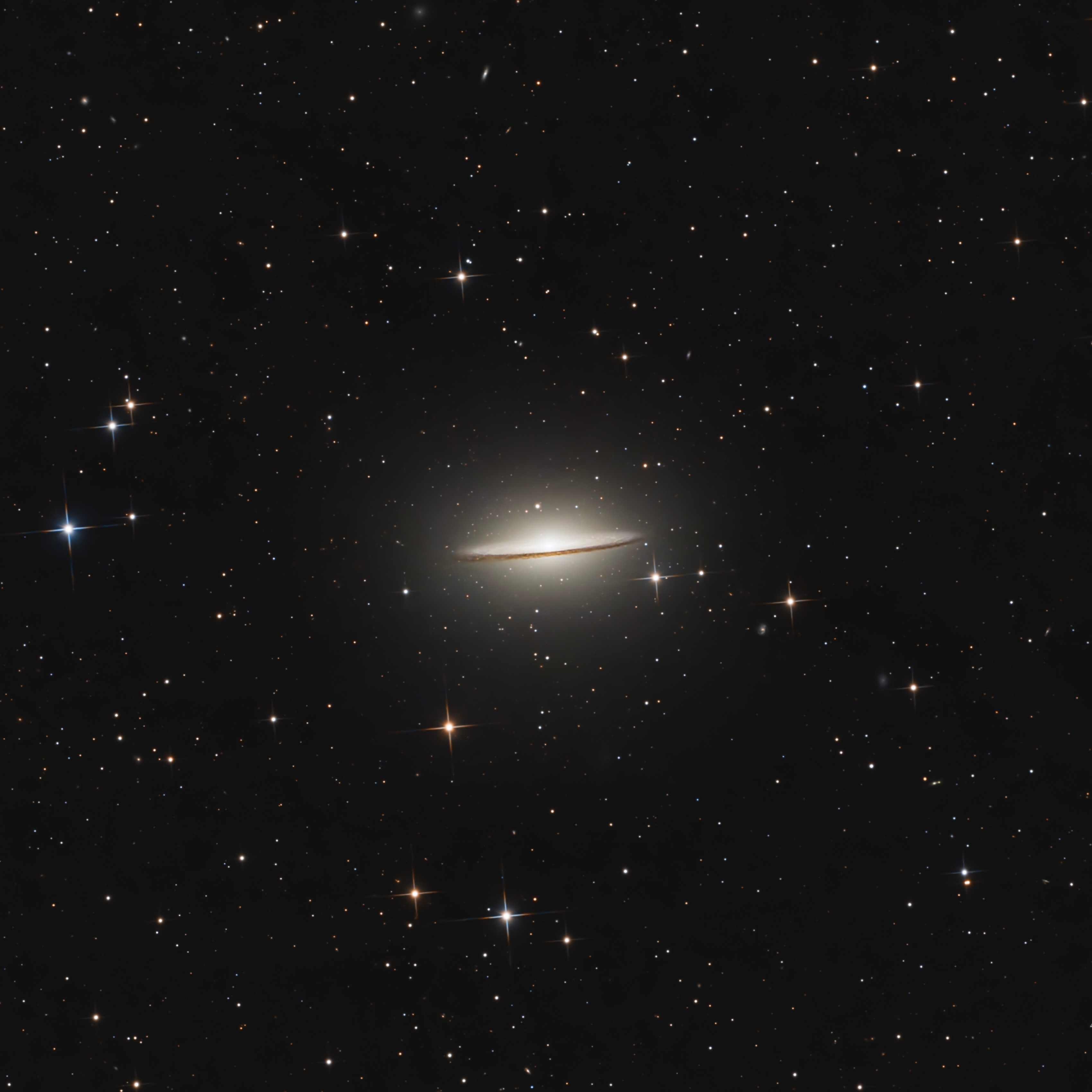 The Sombrero Galaxy seen edge-on with a thin dark dust lane and bright central bulge.